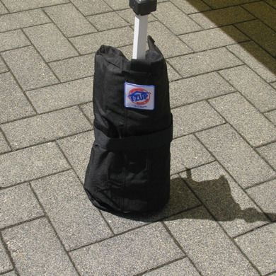 Schwarzer Zeltsack mit Sandfüllung zur Stabilisierung eines Zeltbeins, befestigt mit Klettverschluss,…