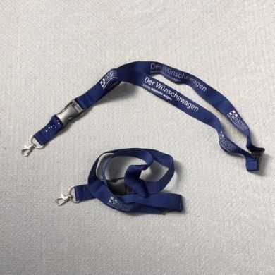 Dunkelblaues Schlüsselband mit Aufdruck „Der Wünschewagen“, Clip-Verschluss und silbernem Metallhaken.